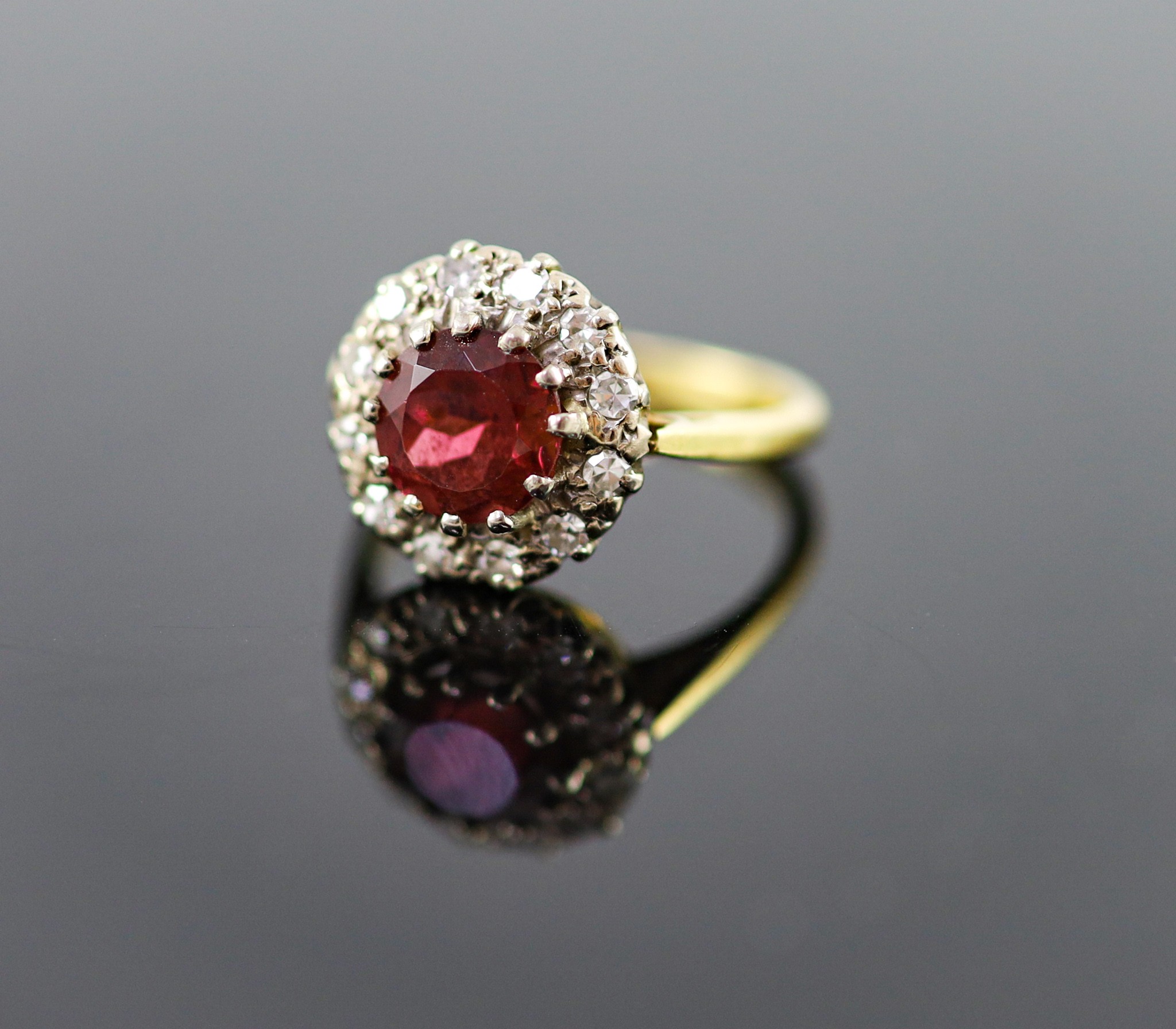 A modern 18ct gold, deep pink tourmaline and diamond set oval cluster ring